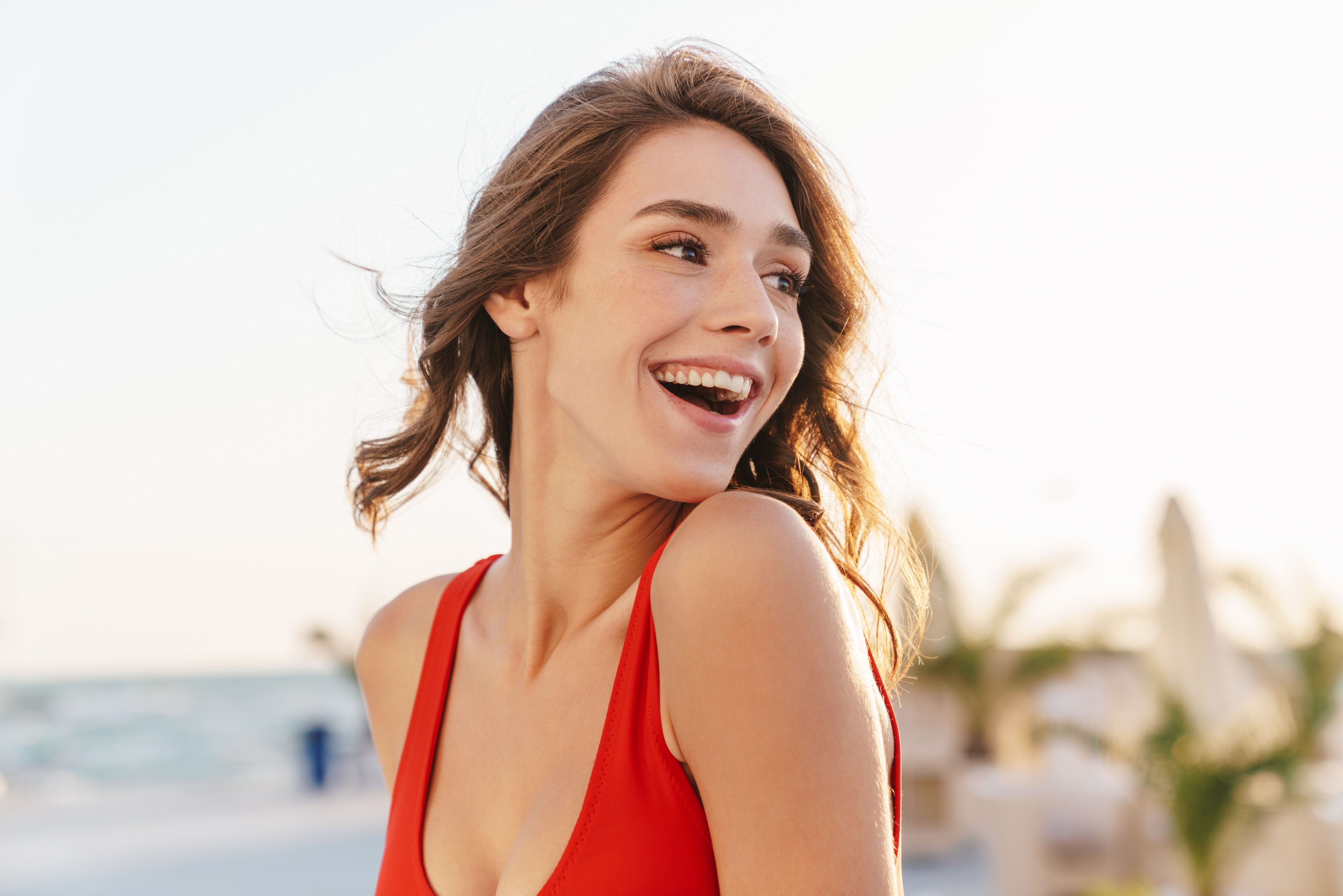 Woman looking over her shoulder at the beach while wearing a red summer bra.jpeg